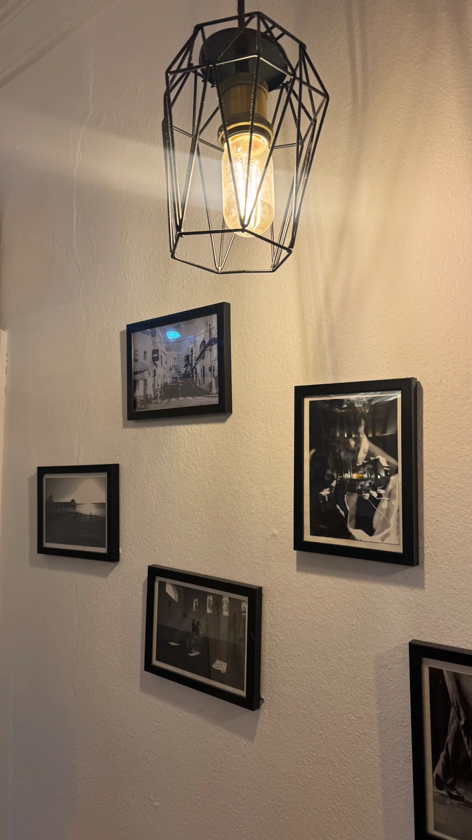 Lámpara de rejilla y fotografías enmarcadas del local