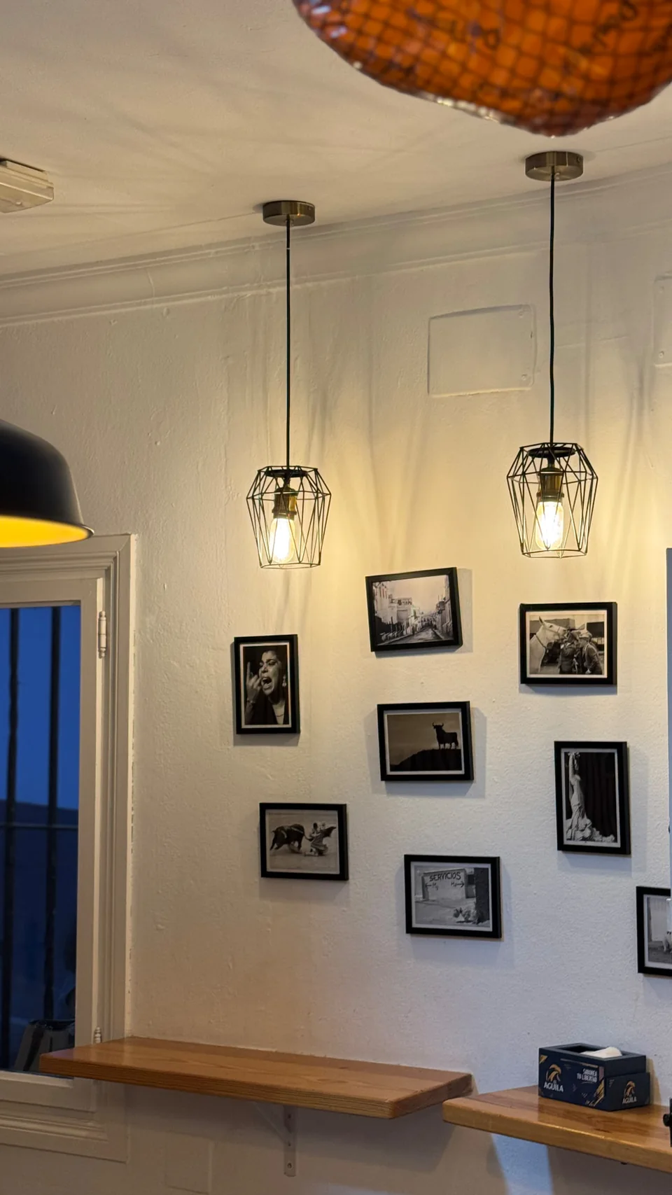 Interior con lámparas de rejilla y fotografías en blanco y negro