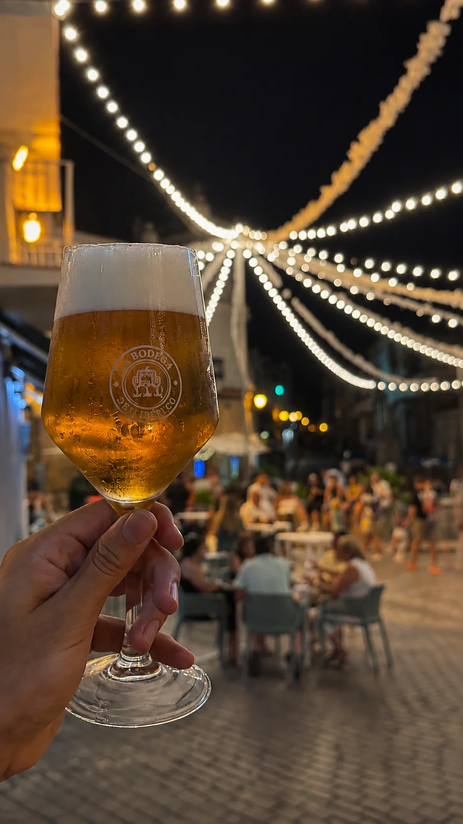 Caña servida en la terraza de La Bodega del Ibérico bajo luces de feria